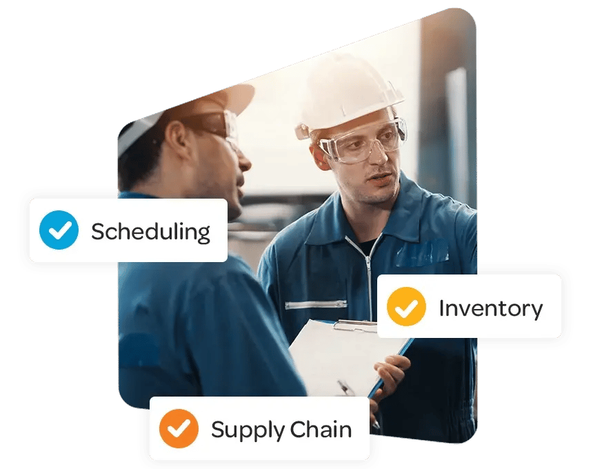 Two engineers wearing blue uniforms, white hard hats, and clear safety glasses conducting a supervision