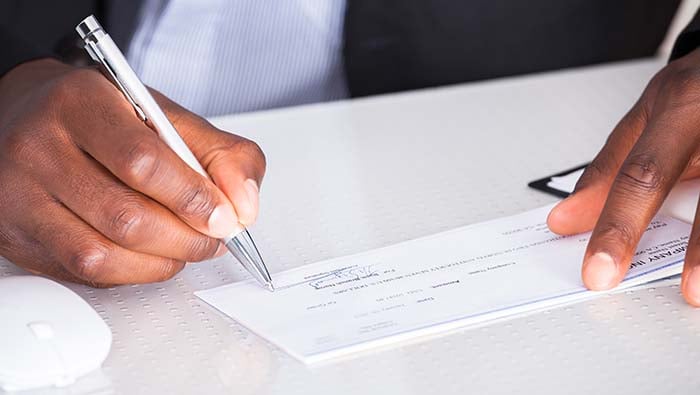 Business person writing on a cheque