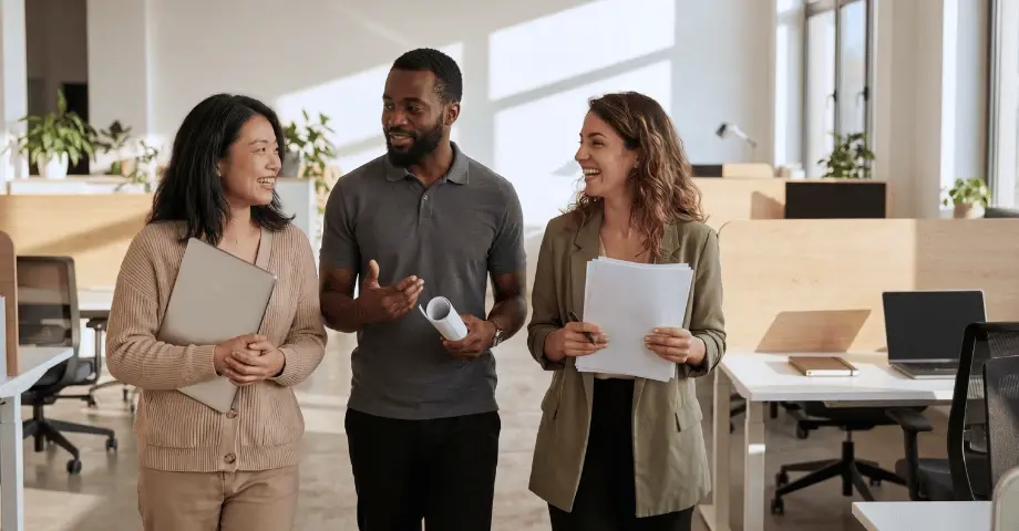 Team members walking through a modern office discussing work together.