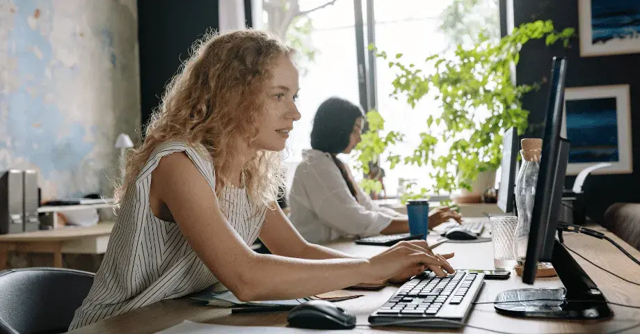 Two business people typing on their computers