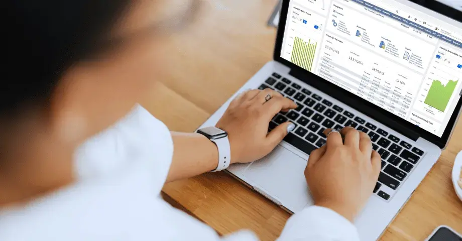 Business person navigating NetSuite dashboard on computer